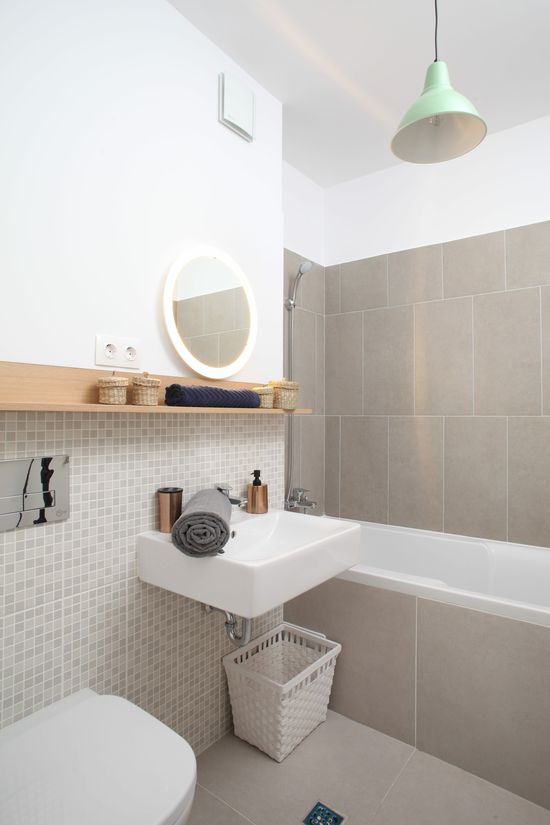 Cromatica în culori neutre completată de elemente din lemn a fost aleasă și pentru baie. Plăcile ceramice provin de la Delta Studio, iar etajera și accesoriile din jurul său au fost cumpărate de la IKEA. Foto: Sorin Iacob